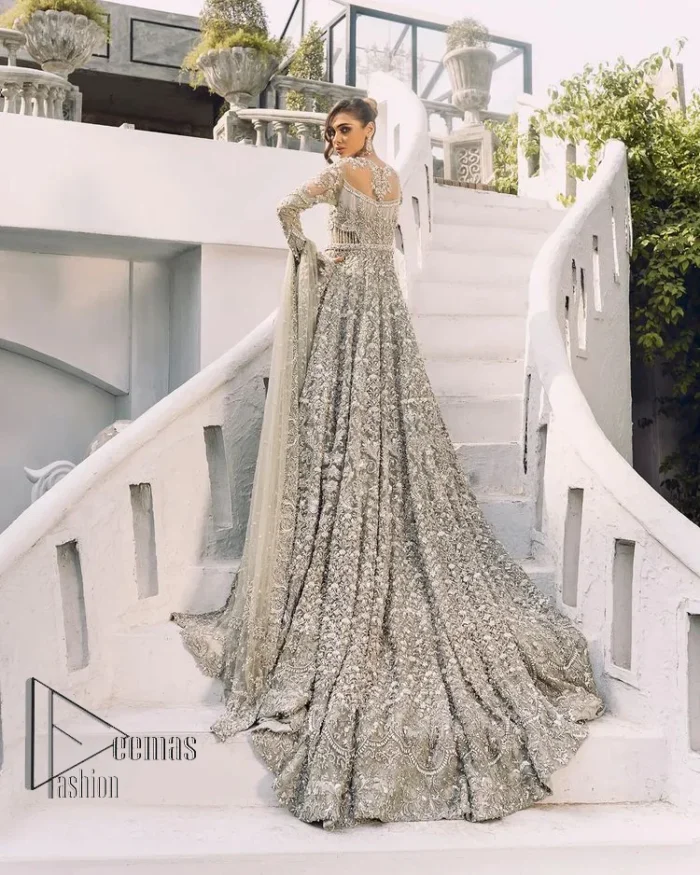 It was love at first swipe! Presenting this olive green back train maxi which is laboriously hand-rendered with silver and matching embroidery to make you a pure soulful bride. It is enhanced with tilla, dabka, kora and Kundan. The illusion neckline adds more beauty to this walima wear when comes with full sleeves. The back train flare is made just for you to catch more and more love from your loved ones. Complete this walima wear with a dupatta in the same colour which is handsomely embellished with a four-sided heavy border and sequins sprayed all over to receive more love.