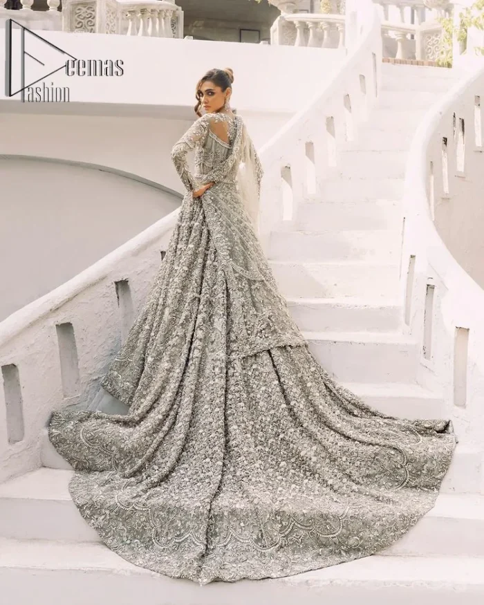 It was love at first swipe! Presenting this olive green back train maxi which is laboriously hand-rendered with silver and matching embroidery to make you a pure soulful bride. It is enhanced with tilla, dabka, kora and Kundan. The illusion neckline adds more beauty to this walima wear when comes with full sleeves. The back train flare is made just for you to catch more and more love from your loved ones. Complete this walima wear with a dupatta in the same colour which is handsomely embellished with a four-sided heavy border and sequins sprayed all over to receive more love.