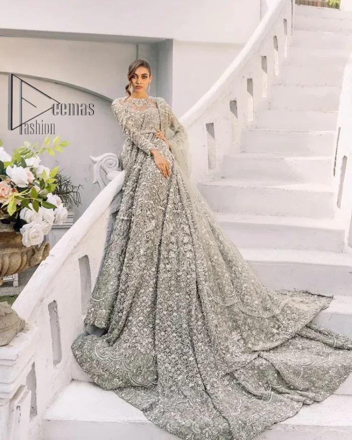 It was love at first swipe! Presenting this olive green back train maxi which is laboriously hand-rendered with silver and matching embroidery to make you a pure soulful bride. It is enhanced with tilla, dabka, kora and Kundan. The illusion neckline adds more beauty to this walima wear when comes with full sleeves. The back train flare is made just for you to catch more and more love from your loved ones. Complete this walima wear with a dupatta in the same colour which is handsomely embellished with a four-sided heavy border and sequins sprayed all over to receive more love.