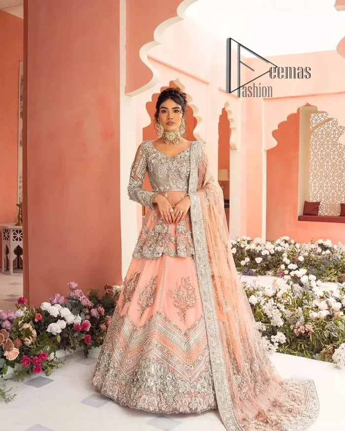 Feeling just peachy. DeemasFashion presents this peachy nikah outfit which begins with peplum in the peach colour. The following peplum is meticulously embellished with a silver embroidery which involves tilla, dabka, kora and Sitara. Further, the V shape neckline of the peplum looks as amazing as the embellished full sleeves. The Nikah outfit is coordinated with a fluffy lehenga having embellished borders and large floral motifs to make your day super peachy. Complete this nikah outfit with a dupatta which is adorned with four-sided embellished borders and floral motifs in the pattern.