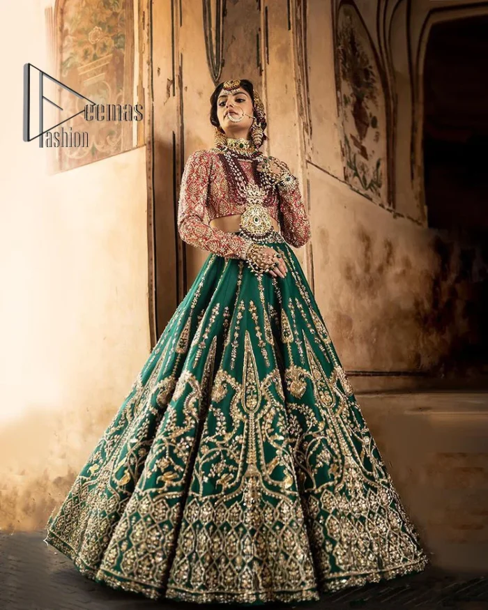 The blushing moment you found your dream mehndi outfit. This mehndi outfit is handsomely and attractively prepared in the level of contrast. Starting this mehndi outfit with a red blouse which is laboriously hand-rendered with light golden embroidery having tilla, kora, dabka and zardozi. In addition to this, it is enhanced with full sleeves and boat shape neckline to make your day super blush. The mehndi outfit is coordinated with a bottle green lehenga which is heavily ornamented with golden embroidery. Complete this article with a golden dupatta having Kiran on all sides. 