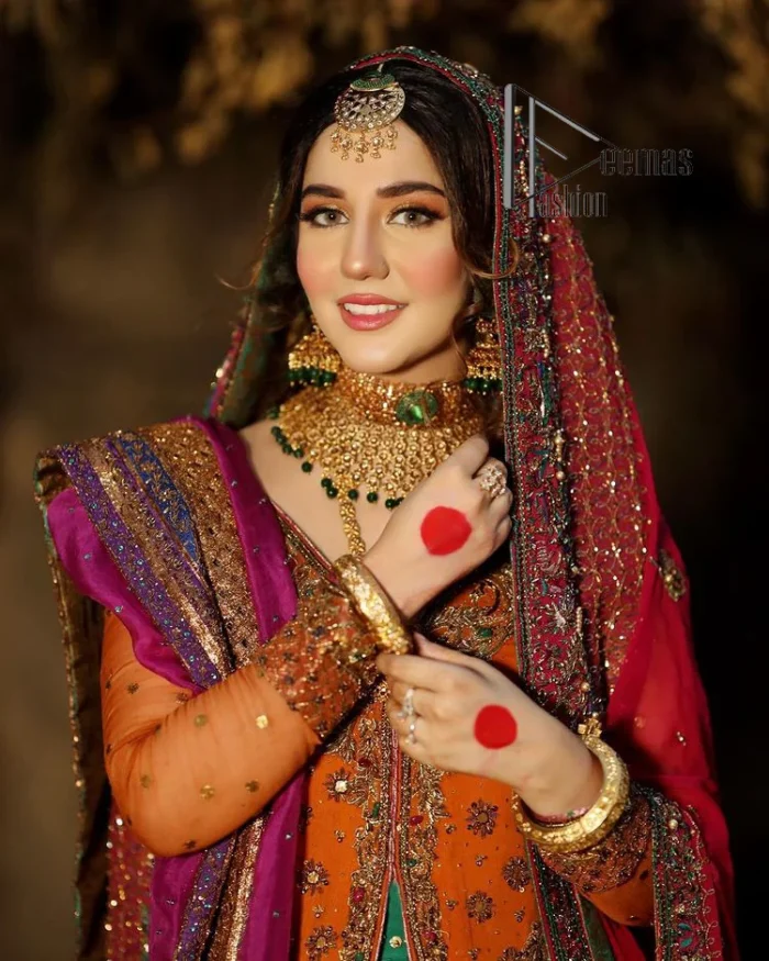 A colourful mehndi outfit is a power which directly influences the soul. Begin this mehndi outfit with a rusted front open shirt which is beautifully decorated with colourful embroidery to give you more power on your mehndi day. It is prominent with tilla, dabka, kora and zardozi. Further, the V shape neckline adds to this mehndi outfit when comes with full sleeves. Paired with a green lehenga having multiple colour borders to give you a more traditional look also. Complete this mehndi outfit with a colourful dupatta which is adorned with four-sided borders and sequins sprayed all over.