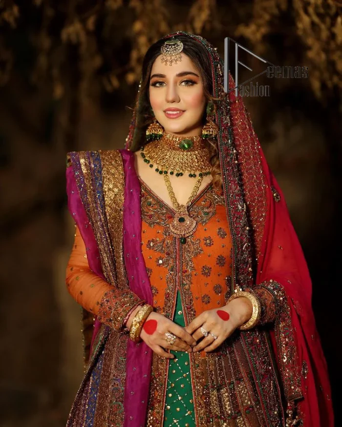 A colourful mehndi outfit is a power which directly influences the soul. Begin this mehndi outfit with a rusted front open shirt which is beautifully decorated with colourful embroidery to give you more power on your mehndi day. It is prominent with tilla, dabka, kora and zardozi. Further, the V shape neckline adds to this mehndi outfit when comes with full sleeves. Paired with a green lehenga having multiple colour borders to give you a more traditional look also. Complete this mehndi outfit with a colourful dupatta which is adorned with four-sided borders and sequins sprayed all over.