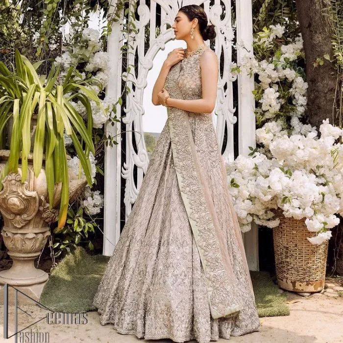 Go with tea rose on your Big day. DeemasFashion presents tea rose nikah wear to fulfil your dreamy look. The blouse in the tea rose colour is heavily ornamented with silver embroidery that enhances with tilla, dabka, kora and zardozi. Further, It is detailed with a round neckline and finished with a sleeveless style. The nikah wear is paired up with can-can lehenga which is heavily embellished to make you the spotlight among all. Complete this article with a dupatta which is enhanced with four-sided embellished borders and sequins sprayed all over to make your day more memorable and attractive.