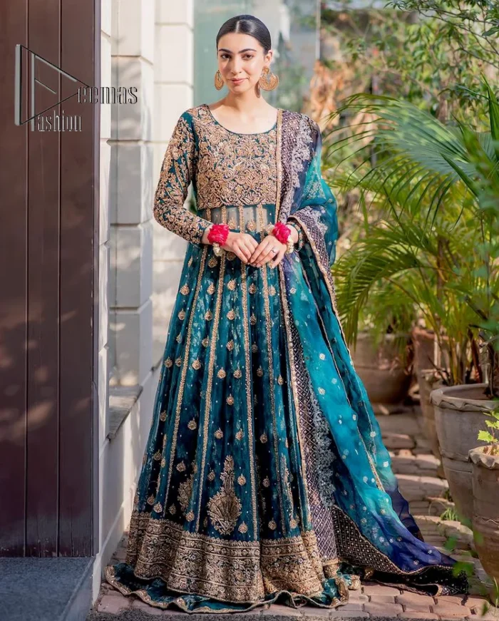 The bride wears blue just touches the blues of the sky. DeemasFashion introduces this teal blue mehndi outfit which begins with panelled Anarkali. The following Anarkali is exquisitely hand-rendered with a light golden embroidery which involves tilla, dabka, kora and zardozi. The floral motifs are also embellished on panels to make this Anarkali priceless. Furthermore, the round shape neckline and full sleeves also enhance the beauty of this mehndi outfit. It is handsomely and attractively paired up with brocade lehenga which gives a unique pieace of charmless.