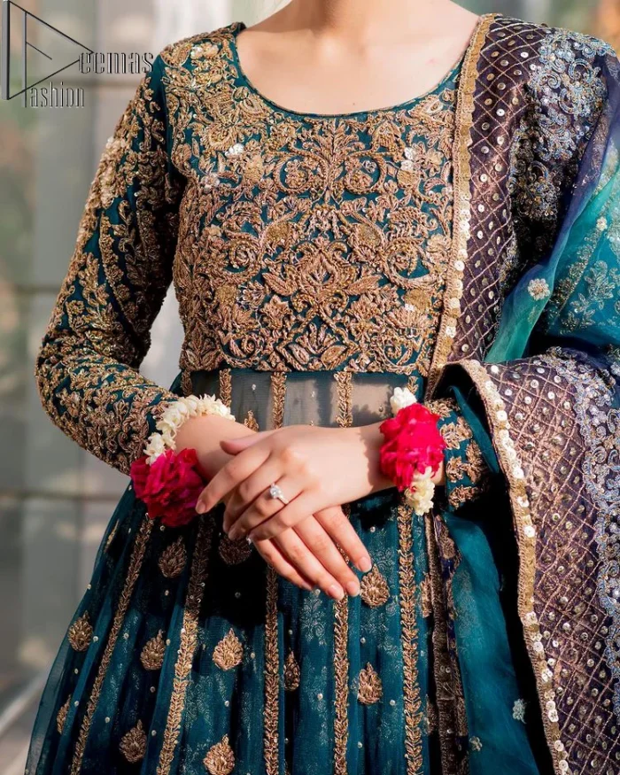 The bride wears blue just touches the blues of the sky. DeemasFashion introduces this teal blue mehndi outfit which begins with panelled Anarkali. The following Anarkali is exquisitely hand-rendered with a light golden embroidery which involves tilla, dabka, kora and zardozi. The floral motifs are also embellished on panels to make this Anarkali priceless. Furthermore, the round shape neckline and full sleeves also enhance the beauty of this mehndi outfit. It is handsomely and attractively paired up with brocade lehenga which gives a unique pieace of charmless.
