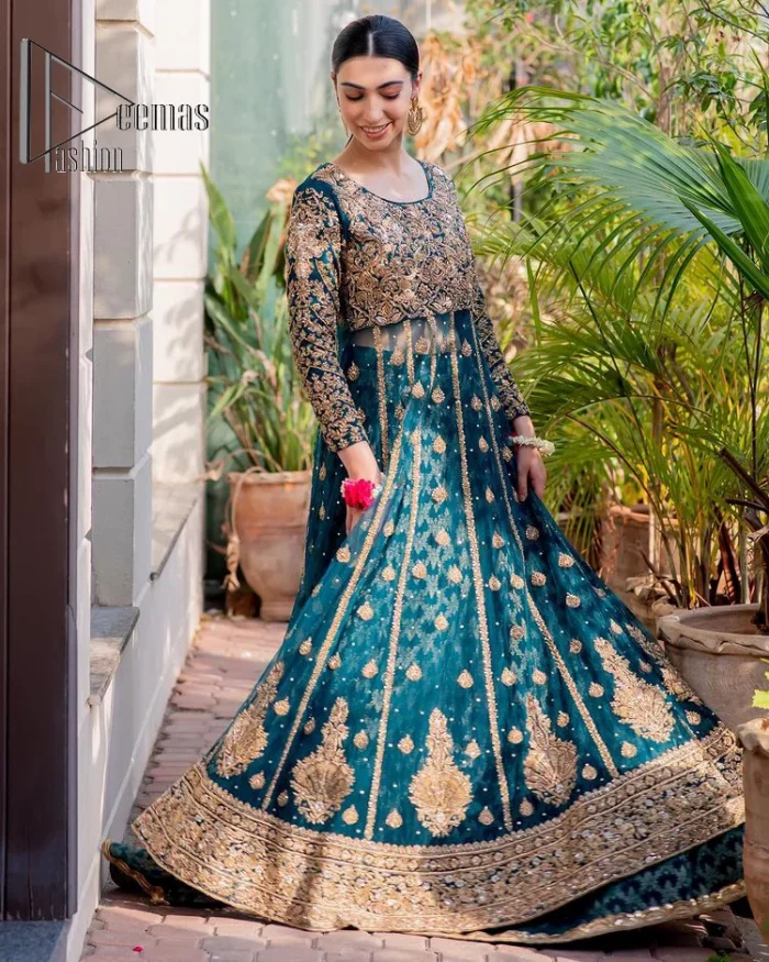 The bride wears blue just touches the blues of the sky. DeemasFashion introduces this teal blue mehndi outfit which begins with panelled Anarkali. The following Anarkali is exquisitely hand-rendered with a light golden embroidery which involves tilla, dabka, kora and zardozi. The floral motifs are also embellished on panels to make this Anarkali priceless. Furthermore, the round shape neckline and full sleeves also enhance the beauty of this mehndi outfit. It is handsomely and attractively paired up with brocade lehenga which gives a unique pieace of charmless.
