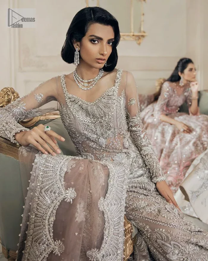Luxurious canvas embodying grace and style! It is a well-crafted short shirt enhanced with silver embroidery accentuated with gleaming ornaments. The following shirt is incrusted with tilla, dabka, kora, zardozi and beautiful detailing of crystal. Further, it is coordinated with a back train lehenga which is meticulously adorned with heavy embroidery to make you the real dreamy fairy. Complete this Walima article with a dupatta in the same colour, framed with a four-sided border. The tiny floral motifs and sequins sprayed spread all over on the dupatta for memorable grace.