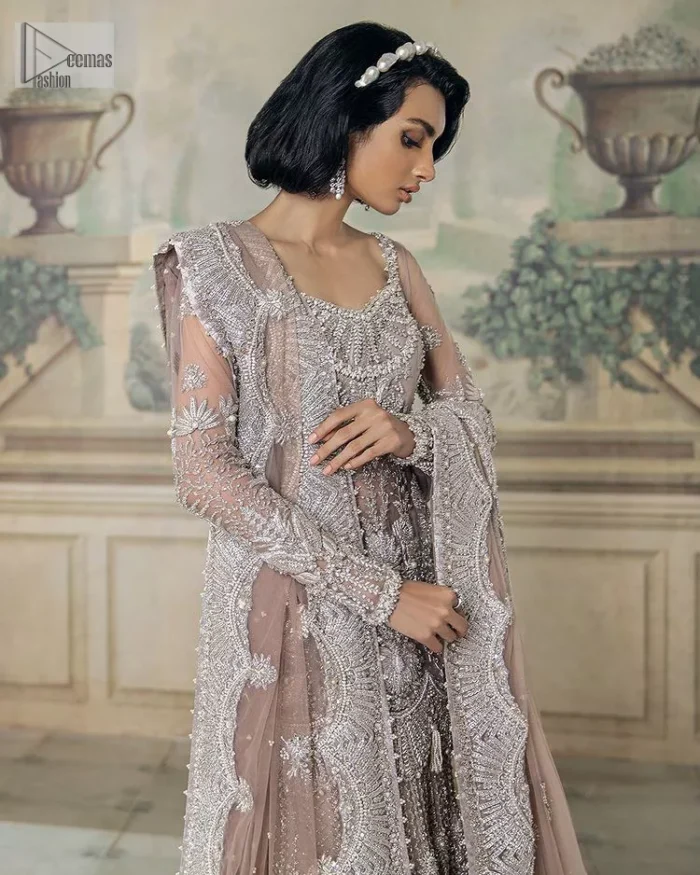 Luxurious canvas embodying grace and style! It is a well-crafted short shirt enhanced with silver embroidery accentuated with gleaming ornaments. The following shirt is incrusted with tilla, dabka, kora, zardozi and beautiful detailing of crystal. Further, it is coordinated with a back train lehenga which is meticulously adorned with heavy embroidery to make you the real dreamy fairy. Complete this Walima article with a dupatta in the same colour, framed with a four-sided border. The tiny floral motifs and sequins sprayed spread all over on the dupatta for memorable grace.