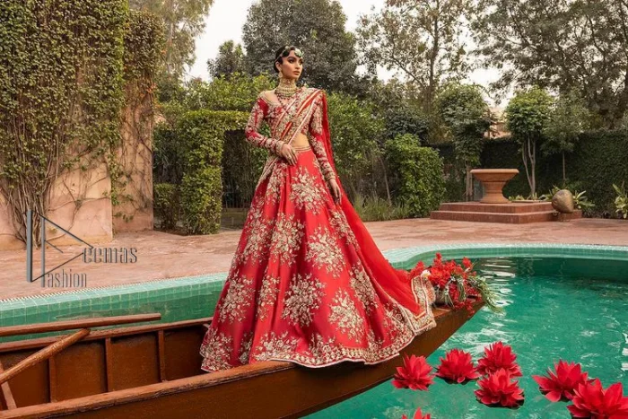 Nothing beats the luxury of bright red couture in reception. Our luxury bright red blouse is entirely hand-worked and finished with the fine material of golden embroidery which is self-explanatory of the uniqueness of the attire. It is further enhanced with tilla, dabka, kora and Sitara. The boat shape neckline also added engaging and attractive beauty to the outfit when comes to full sleeves. It is organized with flared lehenga to make your day super amazing and fulfil your dreamy romantic look. Complete this with a dupatta which is embellished with four-sided borders and sequins sprayed all over to beat the luxury of bright red.