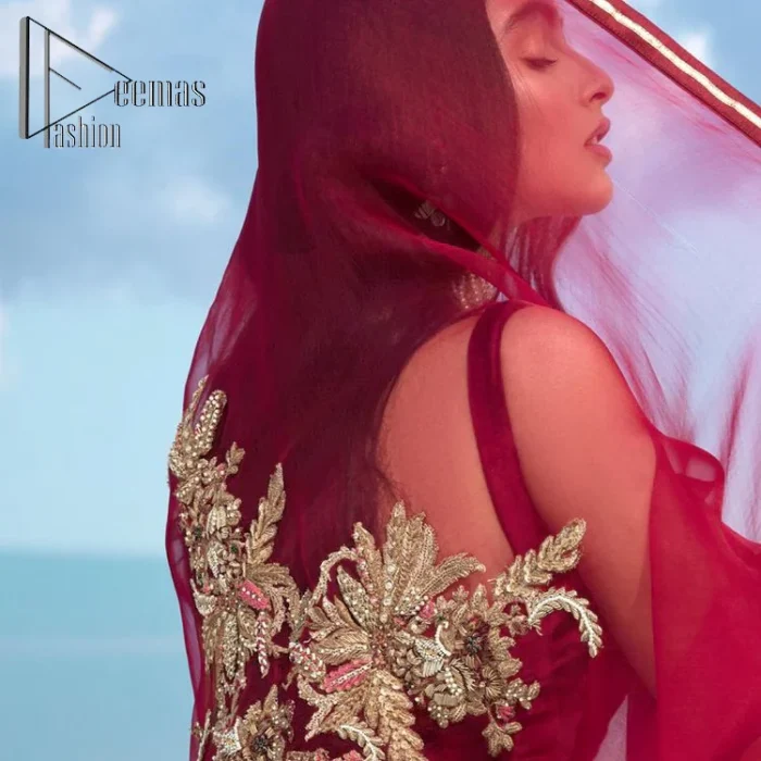 Walking into a new chapter of life with the joy of togetherness and the magic of love. A bright red long shirt is adorned with gorgeous motifs in gold. It is further encrusted with the real magic of tilla, dabka, and kora along with the sequins and pearls. The V shape neckline of this heavy long shirt adds more charm to the outfit when arrives with full sleeves. This beautiful reception piece is paired up with sharara in the same colour with attractive florals that are framed with pearls, Sitara and naqshi that draw the attention of the audience. Complete this article with a dupatta which is adorned with a heavy floral motif to balance the article.