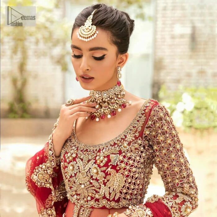 Vibrant outfit to make your reception day more shiny and bright. DeemasFashion presents this maxi in deep red colour, featuring golden embroidery which is enhanced with tilla, dabka, kora, naqshi, zardozi and the magic of Resham. The following scalloped front open maxi has a Round neckline to meet the traditional look when comes with three-quarter sleeves.  In addition to this, it is paired up with a back train lehenga in the same colour framed with embroidery on the border. Complete this article with a scalloped dupatta which is adorned with four-sided borders and sequins sprayed all over for sun-kissed splendour!