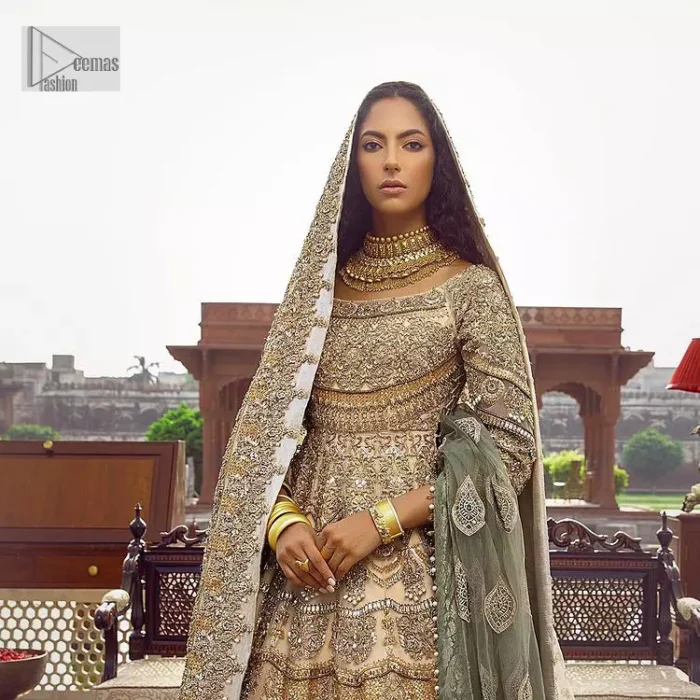 Capturing the essence of modernity on your Nikah with this ivory article. DeemasFashion presents this frock which is intricate with hand embroidery that includes tilla, dabka, kora, Kundan, zardozi and magic of crystal. It is intensified with silver and gold embroidery to make your Qabool Hai moment more delightful and pleasant. Further, the boat shape neckline with three-quarter sleeves strengthens the beauty of the outfit. The following frock is systemized with a lehenga whose border is framed with heavy embroidery. The floral motifs also spread on the lehenga. Complete this outfit with a dupatta in the same colour which is ornamented with four-sided borders and sequins sprayed all over to capture the modern bride.