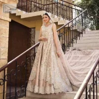 The subtle colour palette, delicate embroidery and eye-catching details. All in all a true style statement! Presenting this light brown maxi which is a luxuriously encrusted masterpiece is laden with tilla, dabka kora, stones,  and delicate Resham. The following front open scalloped maxi is adorned with silver embroidery to make your Nikah day remarkable. The embellished neckline along with the sleeveless style makes you a pretty and unique bride ever. Paired up this article with a sharara whose border is adorned with embroidery. Finish this outfit with a dupatta, framed with four-sided borders and sequins sprayed all over for attractiveness and marvellous details.