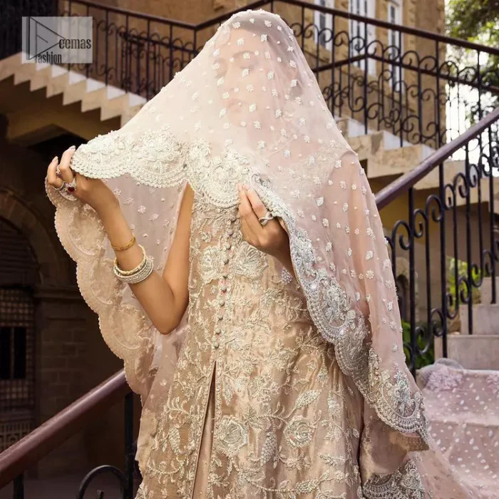 The subtle colour palette, delicate embroidery and eye-catching details. All in all a true style statement! Presenting this light brown maxi which is a luxuriously encrusted masterpiece is laden with tilla, dabka kora, stones,  and delicate Resham. The following front open scalloped maxi is adorned with silver embroidery to make your Nikah day remarkable. The embellished neckline along with the sleeveless style makes you a pretty and unique bride ever. Paired up this article with a sharara whose border is adorned with embroidery. Finish this outfit with a dupatta, framed with four-sided borders and sequins sprayed all over for attractiveness and marvellous details.