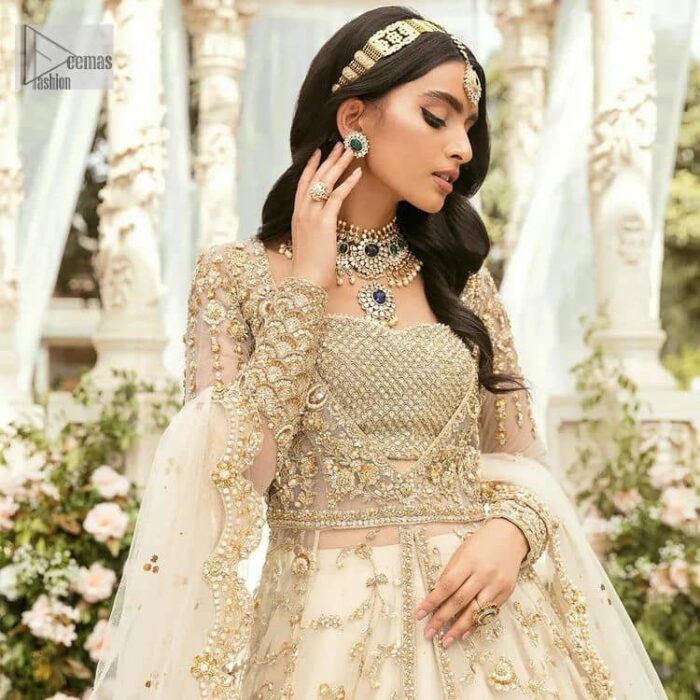 Mark your Nikah day in a calendar as a special one with this marvellous outfit. DeemasFashion presents this outfit in light fawn colour which begins with a back train scalloped maxi. The following maxi is sumptuously embellished with a golden embroidery which is further intensified with tilla, dabka, naqshi, Resham and zardozi. The sweetheart neckline of the maxi is heavily embellished and looks romantic when comes with full sleeves style. It is handsomely paired up with a lehenga in the same colour which is so plain to balance the look of the outfit. Finish this article with a scalloped dupatta which is embellished with four-sided borders and sequins sprayed all over to make your day more magical. 