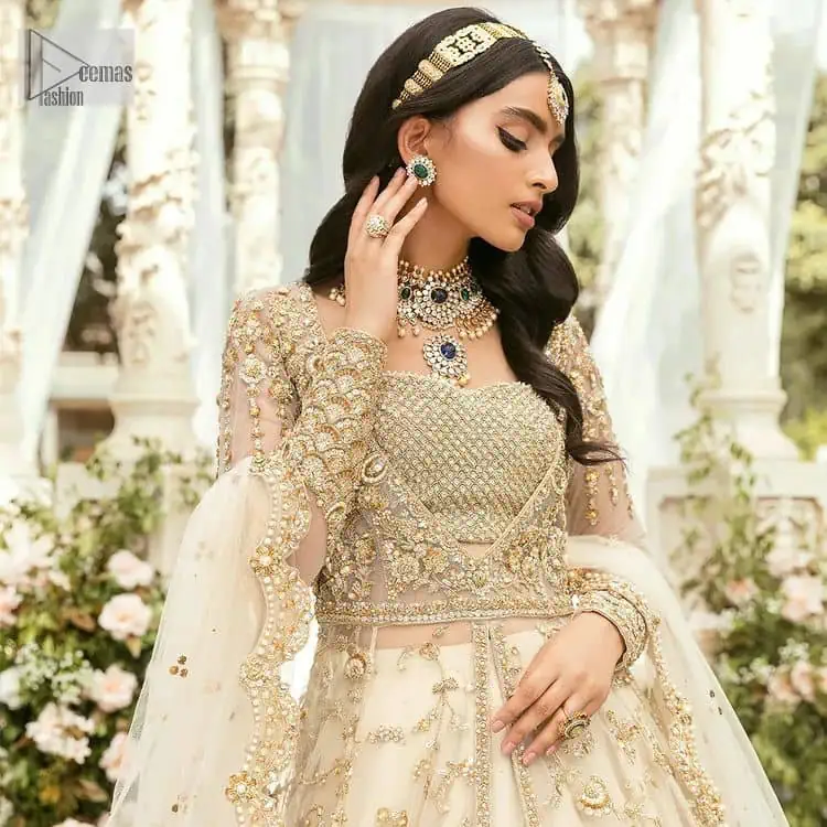 Mark your Nikah day in a calendar as a special one with this marvellous outfit. DeemasFashion presents this outfit in light fawn colour which begins with a back train scalloped maxi. The following maxi is sumptuously embellished with a golden embroidery which is further intensified with tilla, dabka, naqshi, Resham and zardozi. The sweetheart neckline of the maxi is heavily embellished and looks romantic when comes with full sleeves style. It is handsomely paired up with a lehenga in the same colour which is so plain to balance the look of the outfit. Finish this article with a scalloped dupatta which is embellished with four-sided borders and sequins sprayed all over to make your day more magical.