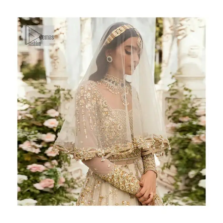 Mark your Nikah day in a calendar as a special one with this marvellous outfit. DeemasFashion presents this outfit in light fawn colour which begins with a back train scalloped maxi. The following maxi is sumptuously embellished with a golden embroidery which is further intensified with tilla, dabka, naqshi, Resham and zardozi. The sweetheart neckline of the maxi is heavily embellished and looks romantic when comes with full sleeves style. It is handsomely paired up with a lehenga in the same colour which is so plain to balance the look of the outfit. Finish this article with a scalloped dupatta which is embellished with four-sided borders and sequins sprayed all over to make your day more magical.
