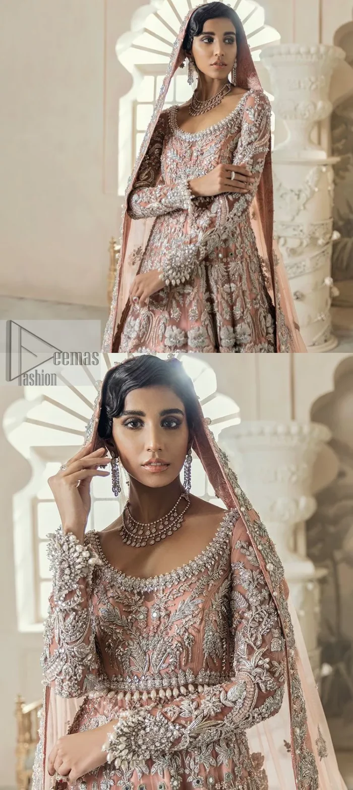 Steal the spotlight at your walima with this light orange yet subtle ensemble! This blouse is in a beautiful shade of orange and is deftly adorned with glowing tilla, dabka and pearls making this ensemble truly ethereal and incandescent. It enhances with the incrusted silver embroidery to make your day. Further, the round neckline of the blouse gives a romantic look when comes with full sleeves. The following blouse is coordinated with a floor-length lehenga which is heavily adorned. The flare of the lehenga adds super beauty to this marvellous masterpiece. Complete this article with a dupatta, framed with a four-sided border and tiny floral motifs all over to steal the spotlight of the show.