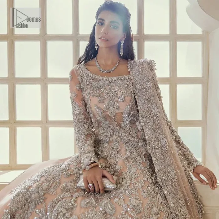 Get yourself a sweet treat, as this ensemble showcases the majestic light orange colour inscribed with lustrous embellishments. A combination of light orange attached grantly to the organza scalloped shirt heightened with silver embroidery. The shirt is intensified with tones of dabka, tilla, kora and blossoms of Resham coupled with a defined sweetheart neckline along with full sleeves. It is coordinated with a flared sharara which is embellished with floral motifs and ornamented borders. This outfit establishes a vibe of its own on your Walima day when finished with a dupatta which is framed with four-sided borders and sequins sprayed all over.