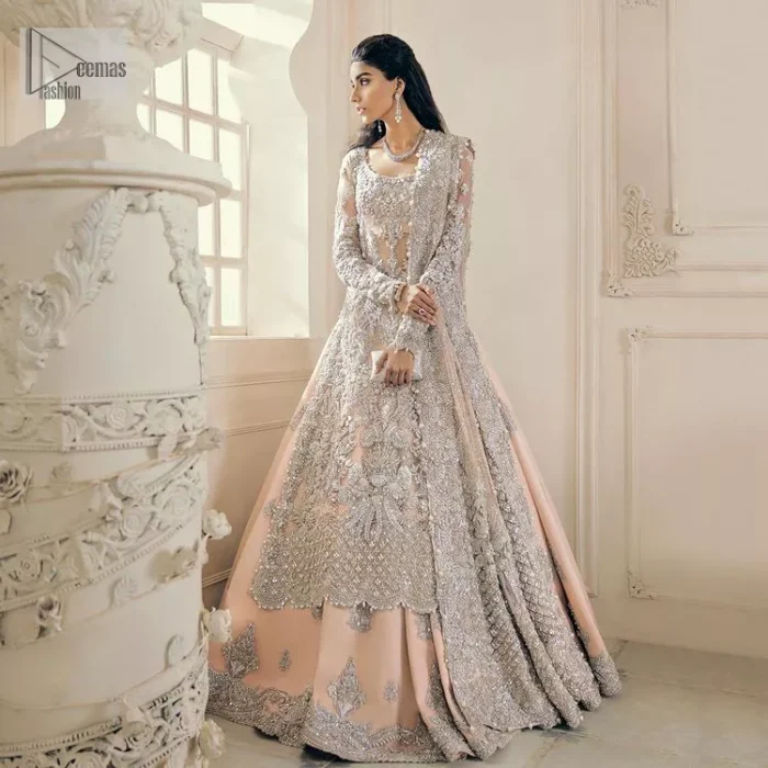 Get yourself a sweet treat, as this ensemble showcases the majestic light orange colour inscribed with lustrous embellishments. A combination of light orange attached grantly to the organza scalloped shirt heightened with silver embroidery. The shirt is intensified with tones of dabka, tilla, kora and blossoms of Resham coupled with a defined sweetheart neckline along with full sleeves. It is coordinated with a flared sharara which is embellished with floral motifs and ornamented borders. This outfit establishes a vibe of its own on your Walima day when finished with a dupatta which is framed with four-sided borders and sequins sprayed all over.