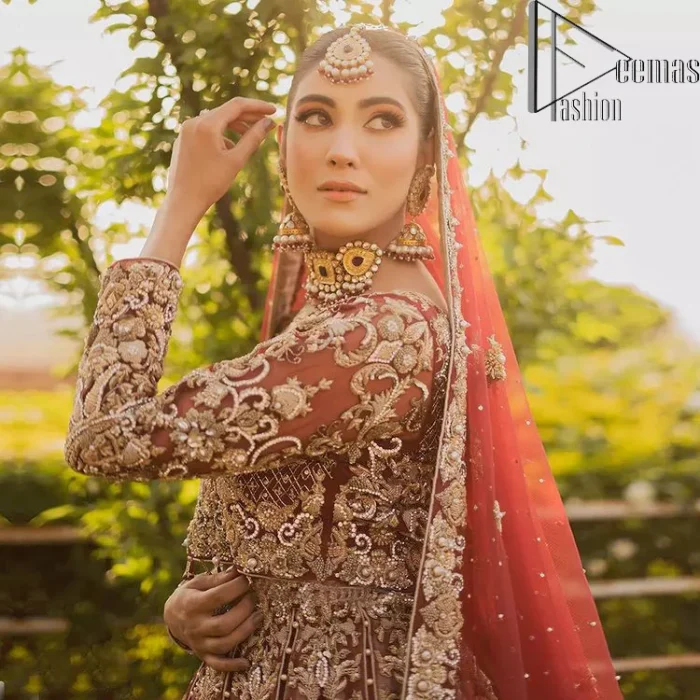 Love is in the air. A maroon blouse in maroon colour is hand-rendered in gold and is enhanced with naqshi, tilla, dabka, and kora along with the magic of zardozi. The boat shape neckline of the following blouse is pleasing to the outfit when combined with full sleeves to make your reception day more memorable. The flared lehenga in the same colours has gorgeous embroidery patterns and is paired up with a dupatta which is framed with a four-sided embellished border. It is further prominent with a sequin spray to give you the look of a model of the era.