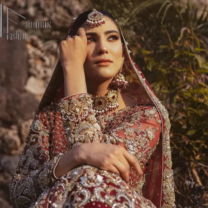 Love is in the air. A maroon blouse in maroon colour is hand-rendered in gold and is enhanced with naqshi, tilla, dabka, and kora along with the magic of zardozi. The boat shape neckline of the following blouse is pleasing to the outfit when combined with full sleeves to make your reception day more memorable. The flared lehenga in the same colours has gorgeous embroidery patterns and is paired up with a dupatta which is framed with a four-sided embellished border. It is further prominent with a sequin spray to give you the look of a model of the era.