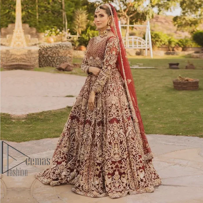 Love is in the air. A maroon blouse in maroon colour is hand-rendered in gold and is enhanced with naqshi, tilla, dabka, and kora along with the magic of zardozi. The boat shape neckline of the following blouse is pleasing to the outfit when combined with full sleeves to make your reception day more memorable. The flared lehenga in the same colours has gorgeous embroidery patterns and is paired up with a dupatta which is framed with a four-sided embellished border. It is further prominent with a sequin spray to give you the look of a model of the era.