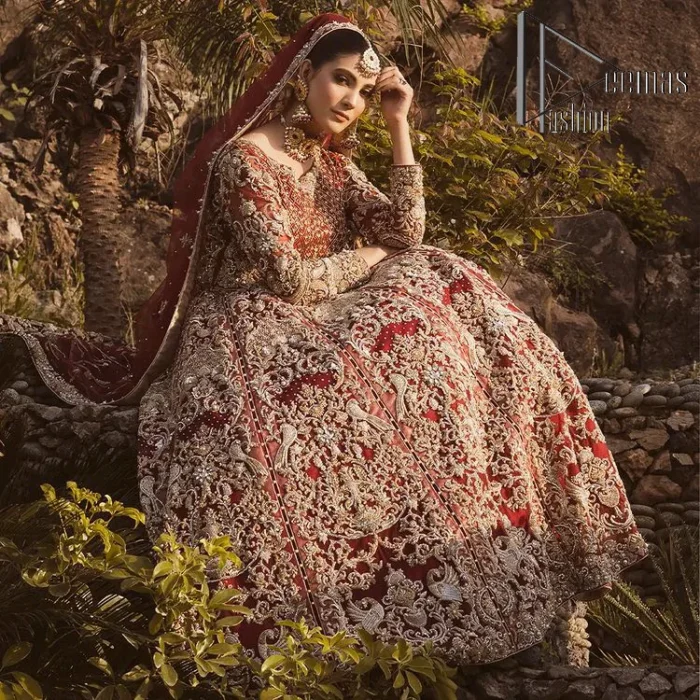 Love is in the air. A maroon blouse in maroon colour is hand-rendered in gold and is enhanced with naqshi, tilla, dabka, and kora along with the magic of zardozi. The boat shape neckline of the following blouse is pleasing to the outfit when combined with full sleeves to make your reception day more memorable. The flared lehenga in the same colours has gorgeous embroidery patterns and is paired up with a dupatta which is framed with a four-sided embellished border. It is further prominent with a sequin spray to give you the look of a model of the era.