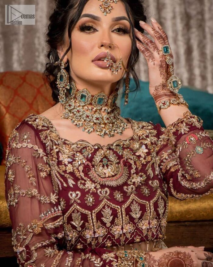 Take your style up a few notches in this elegant reception piece. A pure organza maroon fluffy lehnga is beautifully hand-rendered with golden embroidery and enhanced with  tilla, sitara, pearls, dabka and zardozi work. It is paired up with a blouse choli with tilla motifs on the full sleeves along with boat shape neckline to make your Big day astonishing and remarkable. The ivory organza dupatta has a four-sided embroidery adorned with pearls and Sitara and is framed with a scalloped style.