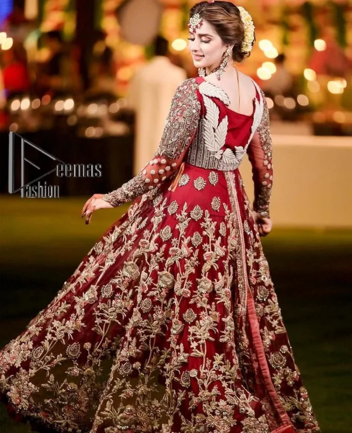 The magic of luxurious romantic silhouettes, giving out love and letting it come in. A maroon frilled maxi that is purely designed for your reception and hand-crafted with Sitara, pearls, tilla , and dabka along with the magic of zardozi. Further, it is handsomely ornamented with multiple embroideries to steal everyone's heart. The round shape neckline enhances the beauty of the outfit when comes with full sleeves to make you the star of the show. The front open style of the maxi truly makes you a unique bride of all eras.