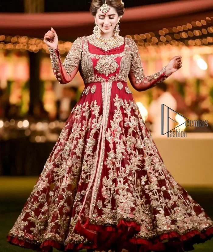 The magic of luxurious romantic silhouettes, giving out love and letting it come in. A maroon frilled maxi that is purely designed for your reception and hand-crafted with Sitara, pearls, tilla , and dabka along with the magic of zardozi. Further, it is handsomely ornamented with multiple embroideries to steal everyone's heart. The round shape neckline enhances the beauty of the outfit when comes with full sleeves to make you the star of the show. The front open style of the maxi truly makes you a unique bride of all eras.
