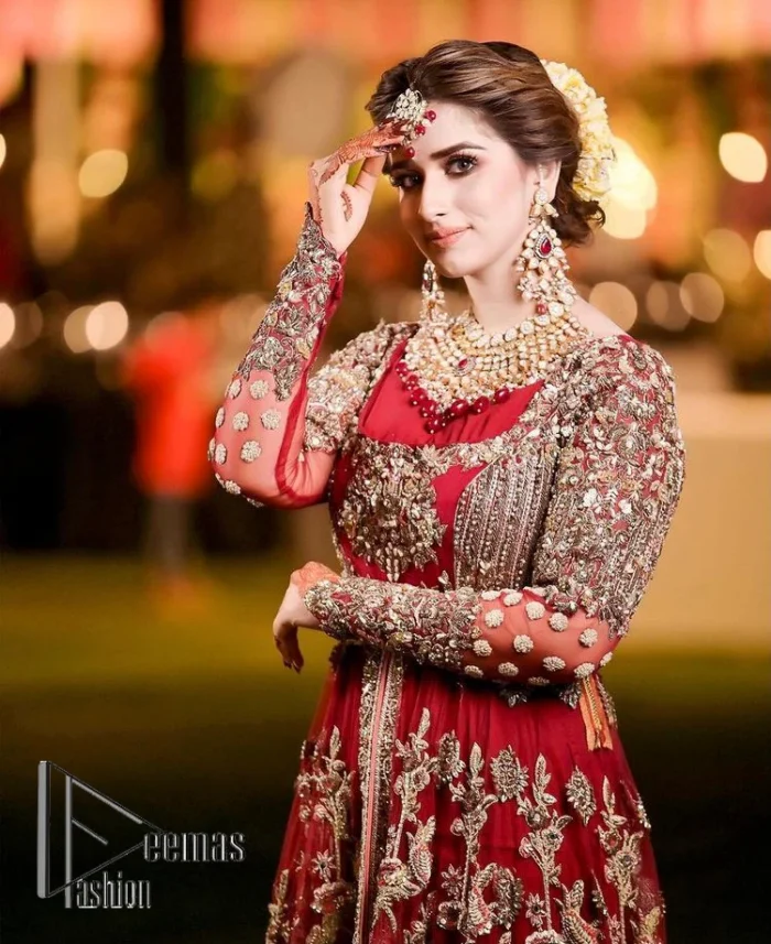 The magic of luxurious romantic silhouettes, giving out love and letting it come in. A maroon frilled maxi that is purely designed for your reception and hand-crafted with Sitara, pearls, tilla , and dabka along with the magic of zardozi. Further, it is handsomely ornamented with multiple embroideries to steal everyone's heart. The round shape neckline enhances the beauty of the outfit when comes with full sleeves to make you the star of the show. The front open style of the maxi truly makes you a unique bride of all eras.