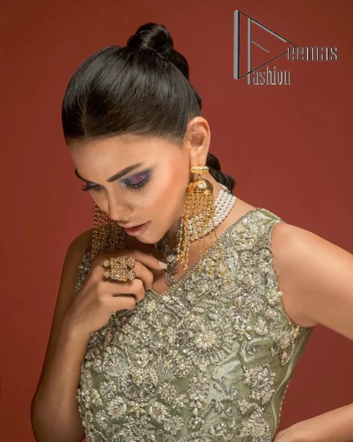 Celebrate your party events with DeemasFashion. An olive green shirt in tissue fabric, hand embellished with dabka, nakshi, cut dana, Resham, Swarovski, Mukesh, sequin and Kundan. A heavily embellished bodice featuring floral patterns all over to make your party event marvellous and shiny. The following heavy shirt is enhanced with V shape neckline along the sleeveless style. The bottom of the shirt has handsome fringes to give you a charming and splendid look.