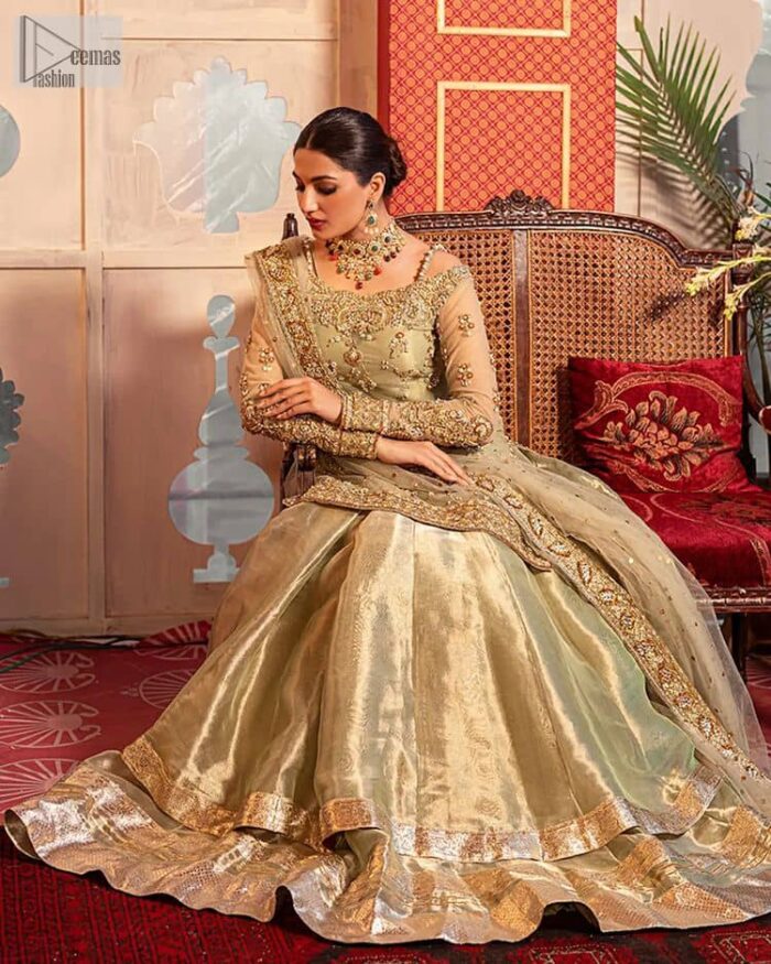 A refreshing colour palette that will make your eyes twinkle and heart sing! A pure organza short shirt in olive green is attractively hand-rendered with golden embroidery and is enhanced with naqshi, Sitara, dabka, tilla, and Zardozi. The strap neckline of this amazing shirt comes with full sleeves to make your Mehndi event more delightful and stunning. The following shirt is paired with double layered lehenga which is just in plane mode to balance the outfit. Complete this traditional look with a dupatta with sequins sprayed all over, framed with a gorgeous embellished four-sided border.