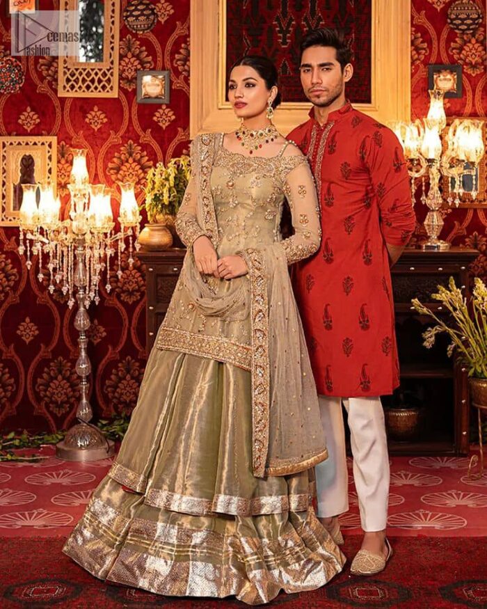 A refreshing colour palette that will make your eyes twinkle and heart sing! A pure organza short shirt in olive green is attractively hand-rendered with golden embroidery and is enhanced with naqshi, Sitara, dabka, tilla, and Zardozi. The strap neckline of this amazing shirt comes with full sleeves to make your Mehndi event more delightful and stunning. The following shirt is paired with double layered lehenga which is just in plane mode to balance the outfit. Complete this traditional look with a dupatta with sequins sprayed all over, framed with a gorgeous embellished four-sided border.