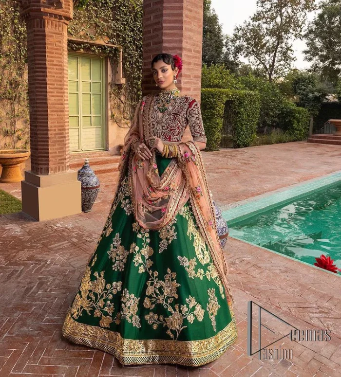 A combination of red and green are here to win hearts at your Mehndi. The attractive lehenga in green colour is hand-rendered with golden embroidery and enhanced with tilla, dabka, kora and zardozi. The floral pattern of the lehenga is followed by attractive border embroidery. It is paired up with a red blouse choli which is beautifully embellished and enhanced with V shape neckline. Further, the half sleeves style of the blouse also added beauty to this outfit. Finish this outfit with a dupatta which is ornamented with four-sided borders and floral motifs all over.