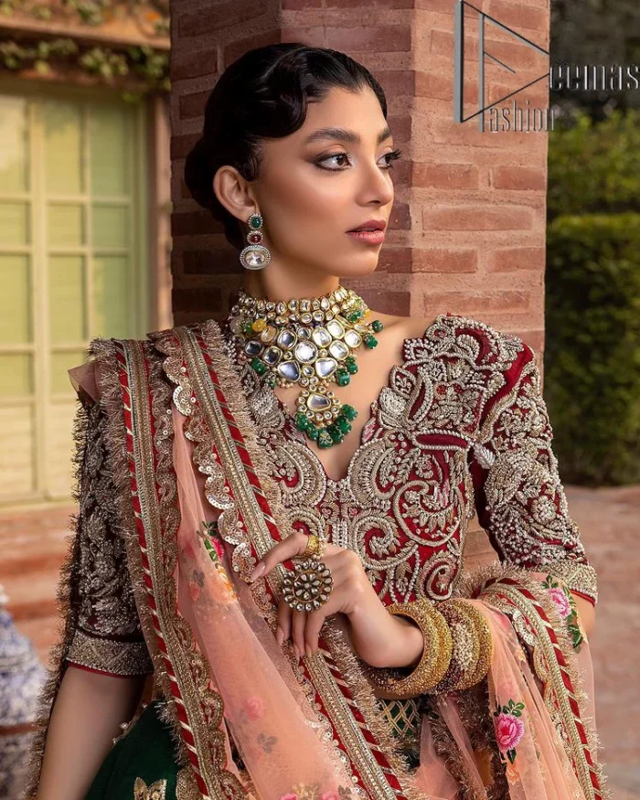 A combination of red and green are here to win hearts at your Mehndi. The attractive lehenga in green colour is hand-rendered with golden embroidery and enhanced with tilla, dabka, kora and zardozi. The floral pattern of the lehenga is followed by attractive border embroidery. It is paired up with a red blouse choli which is beautifully embellished and enhanced with V shape neckline. Further, the half sleeves style of the blouse also added beauty to this outfit. Finish this outfit with a dupatta which is ornamented with four-sided borders and floral motifs all over.