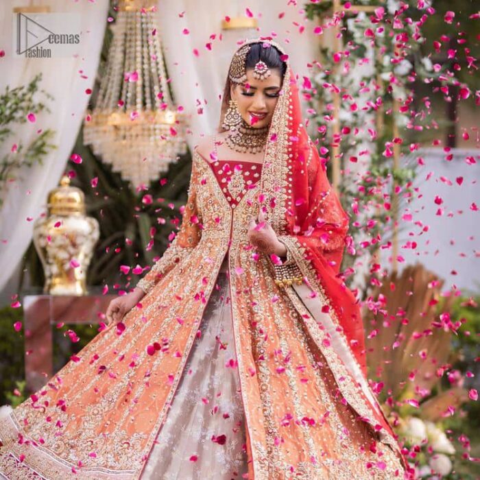 Shine bright in the sparkling ensemble from DeemasFashion. Introducing this reception outfit which begins with a rust pishwas.  This front en pishwas dipped in the richest shade of rust and is ornamented with golden embroidery which is further intensified with tilla, dabka, sequins and the real magic of zardozi. The strap neckline of the pishwas gives a unique aesthetic sense when comes with full sleeves. It is coordinated with an ivory lehenga whose border is embellished with golden embroidery. Finish this article with a dupatta framed with a four-sided embroidered border and sequin sprayed all over.