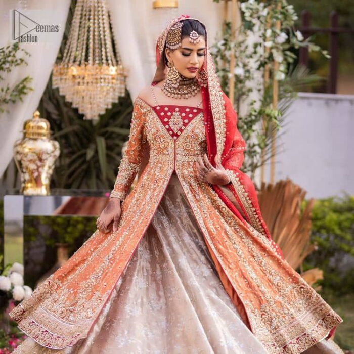 Shine bright in the sparkling ensemble from DeemasFashion. Introducing this reception outfit which begins with a rust pishwas.  This front en pishwas dipped in the richest shade of rust and is ornamented with golden embroidery which is further intensified with tilla, dabka, sequins and the real magic of zardozi. The strap neckline of the pishwas gives a unique aesthetic sense when comes with full sleeves. It is coordinated with an ivory lehenga whose border is embellished with golden embroidery. Finish this article with a dupatta framed with a four-sided embroidered border and sequin sprayed all over.