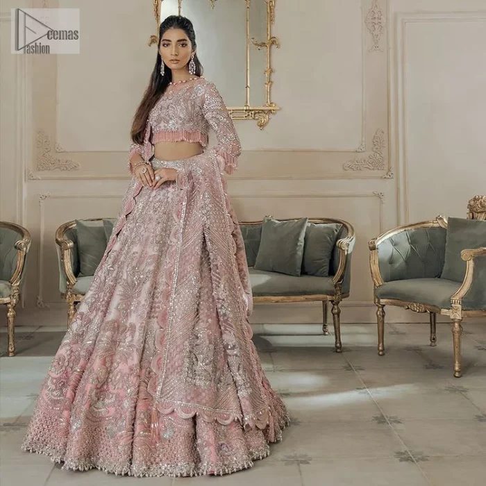 A tea rose in full bloom is truly but a pretty sight, something worth wearing on your Walima. DeemasFashion presents the tea rose blouse with a jewel neckline and half-sleeve style. The following blouse is handcrafted with silver embroidery, this luxuriously encrusted masterpiece is laden with tilla, dabka, zardozi, Resham and the delicate magic of crystal stones. It is beautifully organized with a can-can lehenga which is heavily adorned with embroidery to stole everyone's heart. Finish this article with a scalloped dupatta in the same colour which is framed with a four-sided embellished border to make your day remarkable.