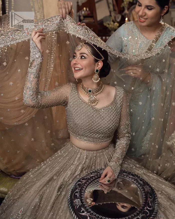 Regal and Charismatic - This is all the outfit is about! A desirable beige lehenga and choli are entirely heavily embroidered with silver colour and embellished with sequins, tilla, naqshi, Zardozi and Dabka. Its stunning heavily embellished blouse has full sleeves and the blouse consists of V shape neckline. It is coordinated with flared lehenga which is adorned with beautiful embroidery to make this walima wear balance. Finish this with a dupatta that has silver sequin and tiny floral motifs all over. The dupatta is framed with a four-sided embellished border to make this masterpiece unique and attractive.