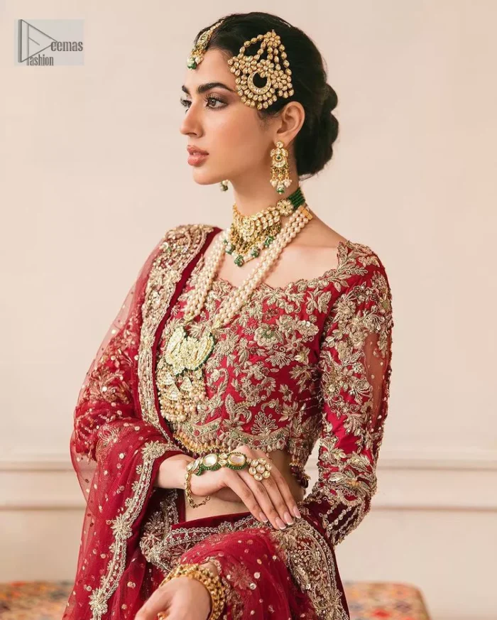 This outfit is a stand-out look for the Pakistani reception, this ensemble consists of a bright red-hued lehenga choli. This light golden embroidery is done with dense handsome work with the detailing of tilla, dabka, kora, zardozi and stone. The boat shape neckline of the following scalloped blouse intensifies the overall beauty of the outfit. Further, the beautiful floral patterns on three-quarter sleeves make this blouse super charming and ten times attractive. It is teamed up with can-can lehenga in the same colour that is ideal for the brides who want to be a queen on her Bug day. The outfit is paired with a dupatta heavily embellished all around the border, with a centre spray of sequins.