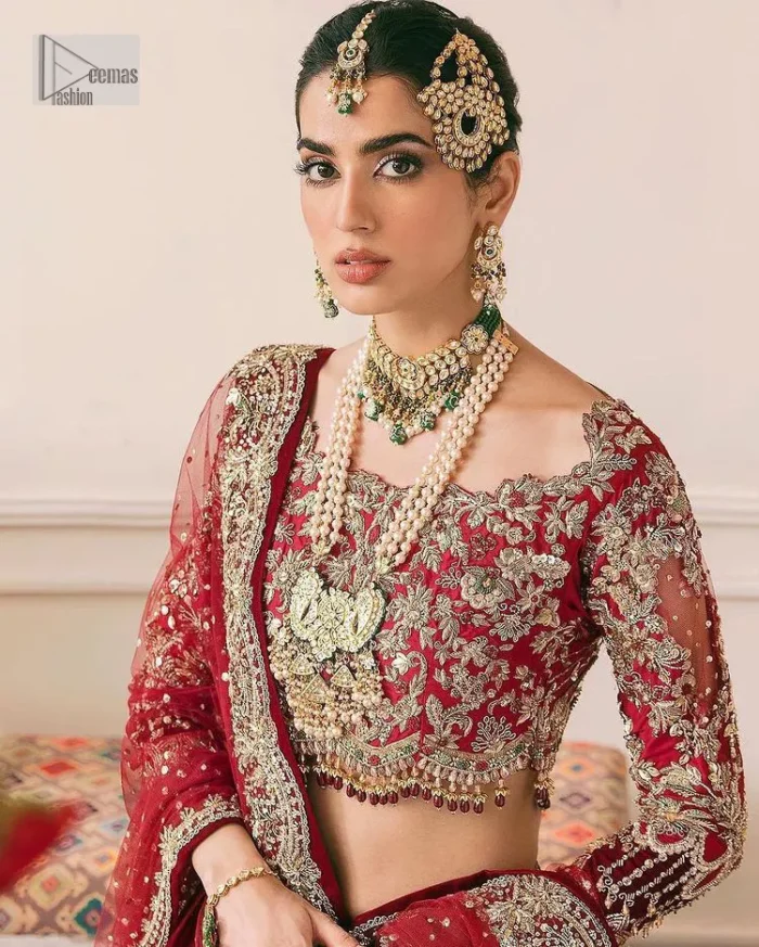This outfit is a stand-out look for the Pakistani reception, this ensemble consists of a bright red-hued lehenga choli. This light golden embroidery is done with dense handsome work with the detailing of tilla, dabka, kora, zardozi and stone. The boat shape neckline of the following scalloped blouse intensifies the overall beauty of the outfit. Further, the beautiful floral patterns on three-quarter sleeves make this blouse super charming and ten times attractive. It is teamed up with can-can lehenga in the same colour that is ideal for the brides who want to be a queen on her Bug day. The outfit is paired with a dupatta heavily embellished all around the border, with a centre spray of sequins.