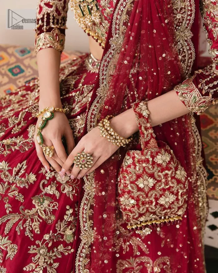 This outfit is a stand-out look for the Pakistani reception, this ensemble consists of a bright red-hued lehenga choli. This light golden embroidery is done with dense handsome work with the detailing of tilla, dabka, kora, zardozi and stone. The boat shape neckline of the following scalloped blouse intensifies the overall beauty of the outfit. Further, the beautiful floral patterns on three-quarter sleeves make this blouse super charming and ten times attractive. It is teamed up with can-can lehenga in the same colour that is ideal for the brides who want to be a queen on her Bug day. The outfit is paired with a dupatta heavily embellished all around the border, with a centre spray of sequins.