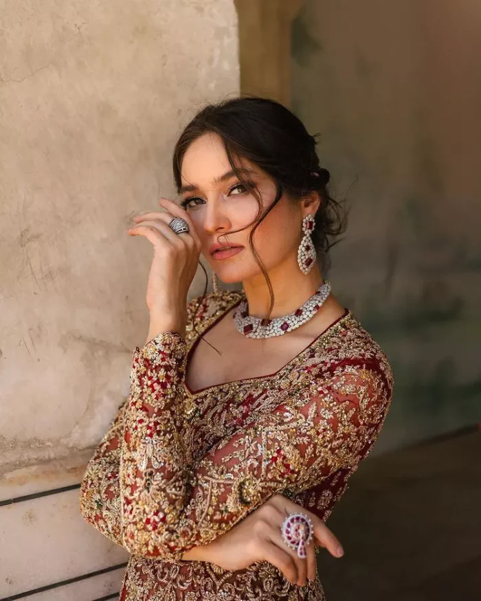 Bright and blissful! This ensemble is the epitome of grace.  The maxi is fully emblazoned with tilla, dabka, kora, Kundan and details of Zardozi. Intricate designs and fine details of golden embroidery give a perfect finishing look to the blouse. Further, embellishment full sleeves give a stunning touch to the blouse. The following blouse is further enhanced with V shape neckline. It is paired up with a lehenga that is ornamented with beautiful embroidery. The Lehenga has a huge flare and long tail. The outfit achieves the final ravishing look when paired with a delicate dupatta. The borders of this dupatta are hand-embellished and decorated with sequins sprayed.