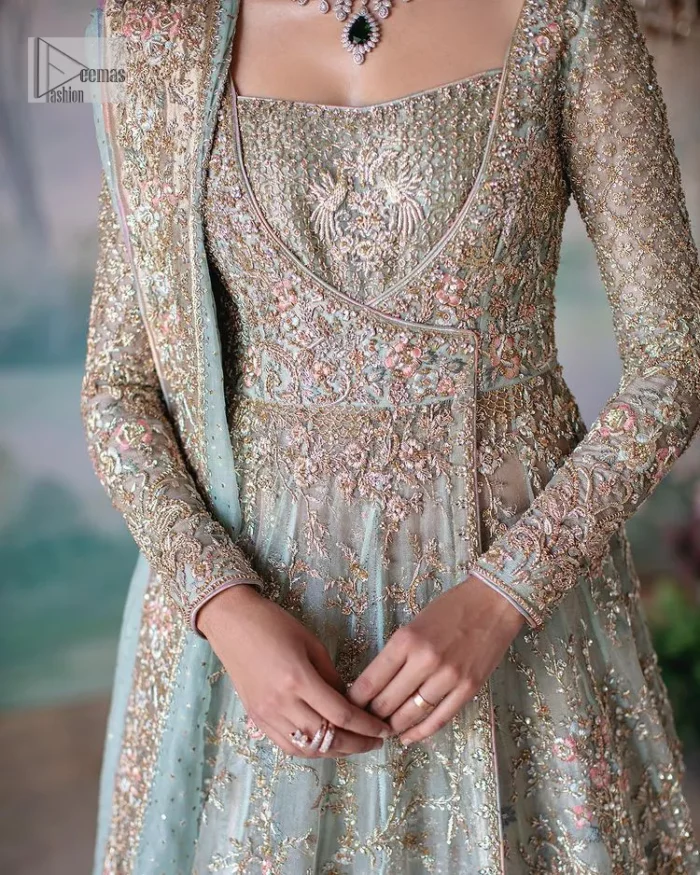 Unique embroidery designs to add some sparkle to your style on your Nikah! Light blue angrakha maxi with delicate multiple colour embroideries and intricate hand embellishments of tilla, dabka, kora, Kundan and crystals on the classic silhouette. Designed to flaunt your best features, the full sleeves carry beautiful embroidery with a square neckline. The following maxi along with the back train lehenga gives this outfit a unique look. Paired with a dreamy dupatta framed with embellished borders, this look is the epitome of ethereal and easy elegance.