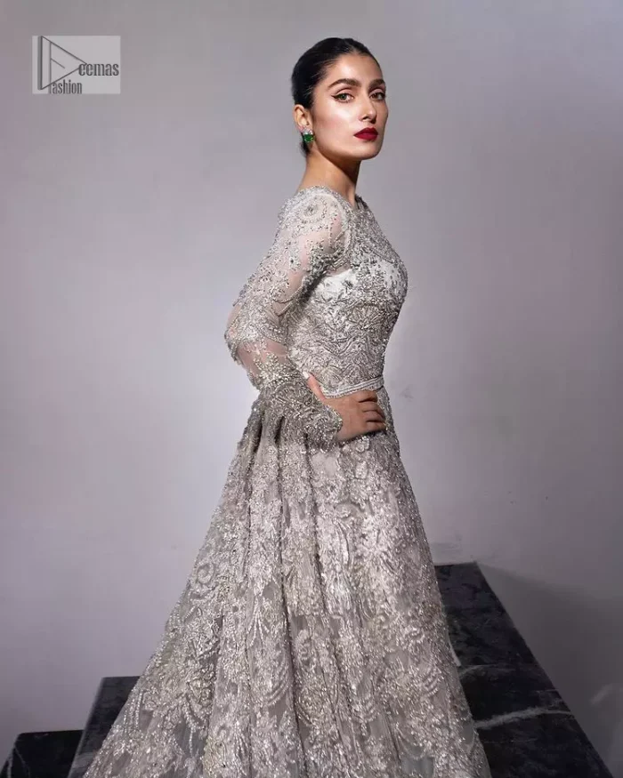 The trend of the back trains is still going strong as nikah wear - Here is the perfect one! This beautiful silver maxi is heavily embellished with silver embroidery. The gorgeous work of pearls, dabka, kora, Kundan and silver stones enhance the overall glamour of this maxi. The extraordinary design of the jewel neckline is completely embellished with silver stones and pearls embroidery combinations. The silver stones touch-up increases the looks of the beautiful gown with long tails that gives everlasting impact and at the bottom is the double flare. The full sleeves of the maxi are the lavishing style that any bride can wear on her big day.