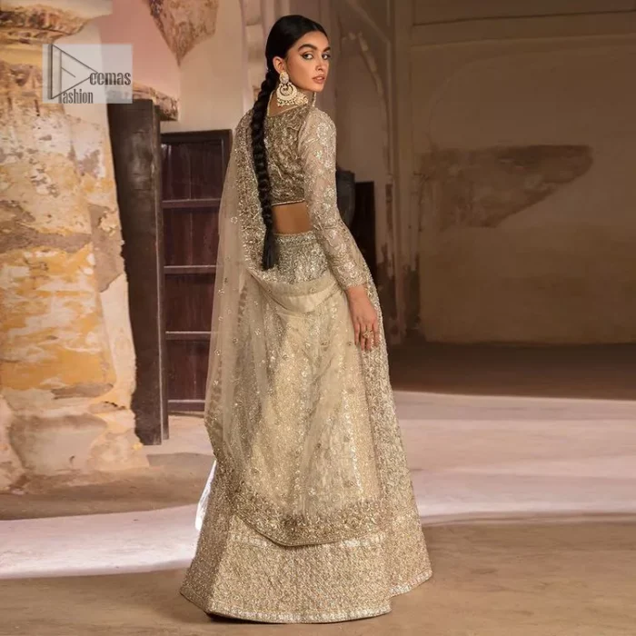The fusion of this silver canvas decorated with vibrant contrasts is all you need to stun on your day! DeemasFashion presents this nikah wear in silver colour which is highlighted with tilla, dabka, kora, Kundan and the real magic of Zardozi. The round neckline of the following blouse has an ethnic charm. It is embellished with silver embroidery to make this masterpiece a dreamy one. The full sleeves style of the blouse also adds beauty to the outfit. It is paired up with a lehenga which is heavily embellished. The stunning dress in the Lehenga Choli style achieves the final charming look when paired with a dupatta in the same colour framed with four-sided borders and sequins sprayed all over. 