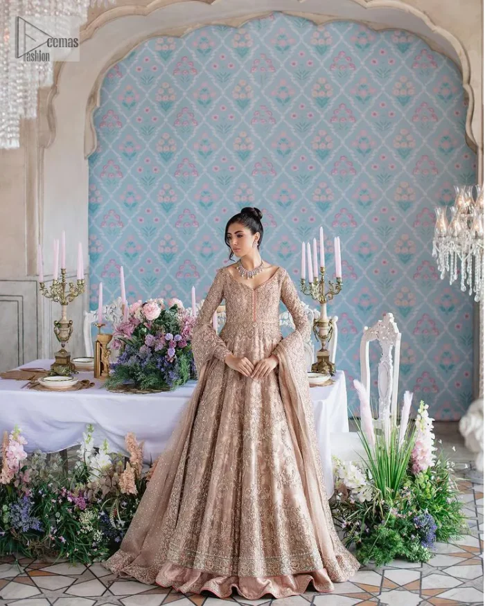Make your Qabool Hai moment more memorable with this outfit by DeemasFashion. A dreamy statement of this dress proffers a soft pink hue with glamorous silver and golden embroidery.  It is further enhanced with tilla, dabka, kora, Kundan and the real magic of zardozi. V neckline enhances the overall glamour of this masterpiece. Intricate designs and fine details on the sleeves give a perfect finishing look to this maxi. The maxi is layered over a meticulously handcrafted lehnga which is bold enough to stand out in the crowd. Finish this article with a dupatta which is ornamented with four-sided borders and sequins sprayed all over which is a unique piece for your Nikah look. 